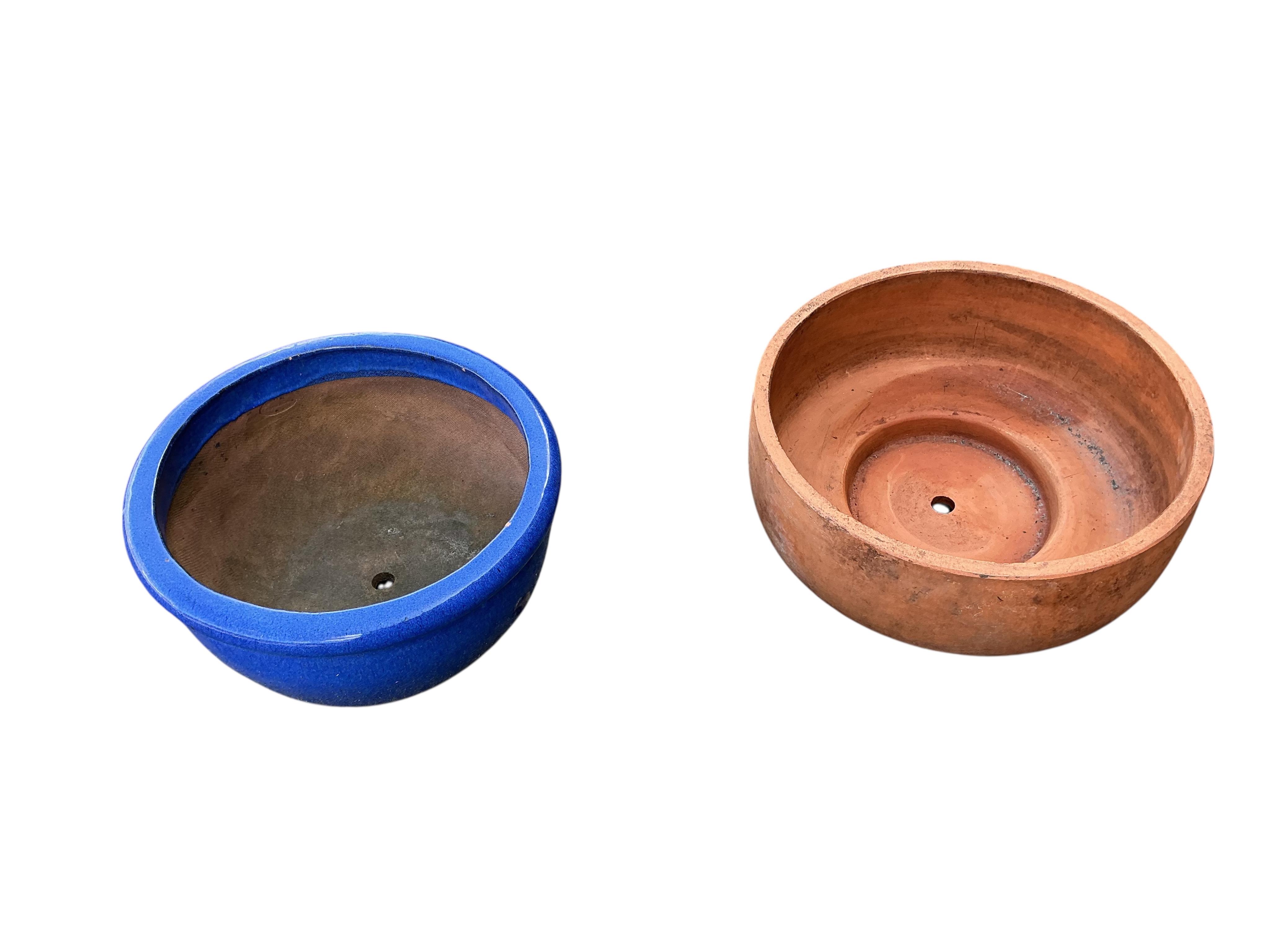 Three terracotta pots and a blue glazed pot, largest diameter 50cm, height 21cm